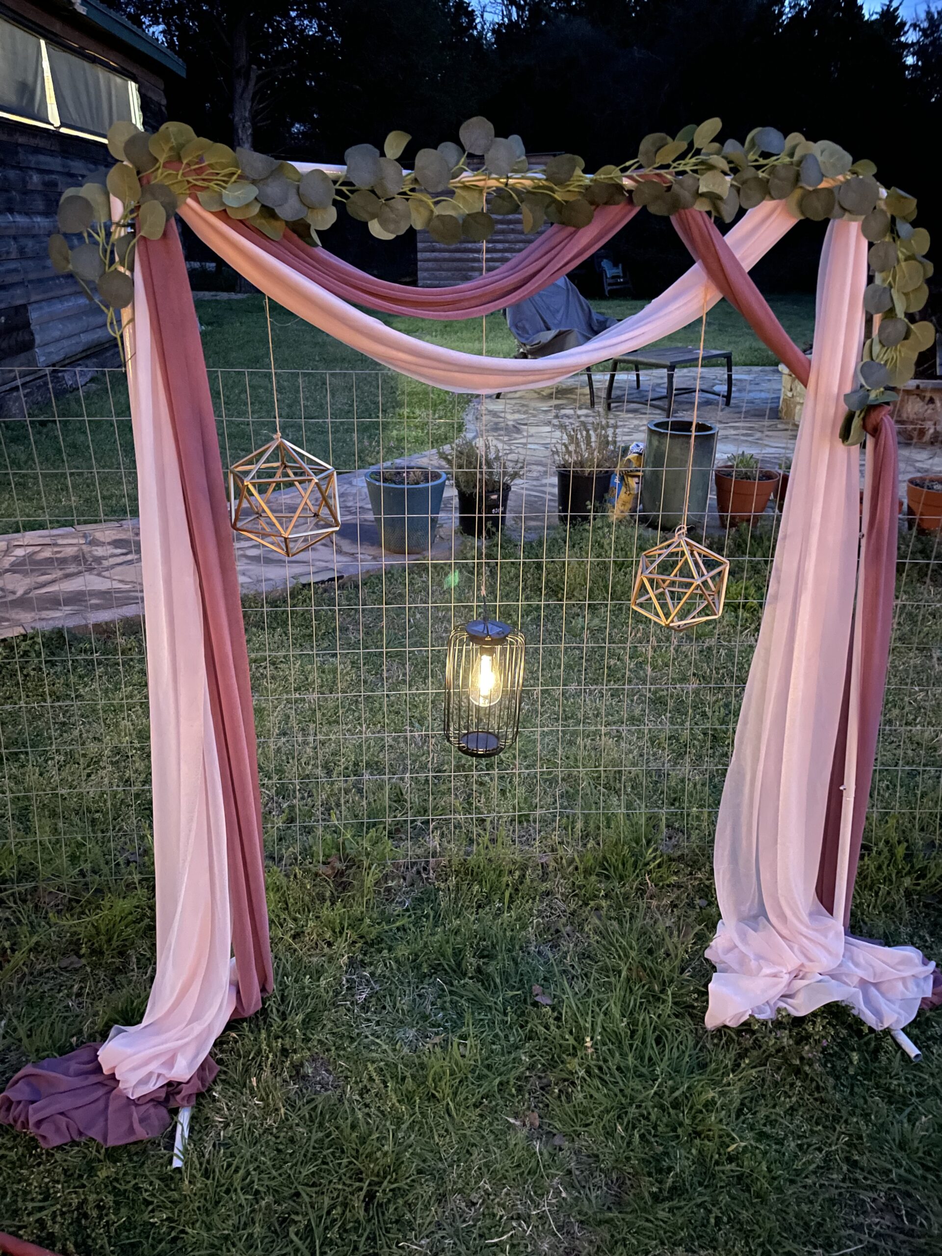 hanging fabrics over a square arch with a lantern hanging in the middle